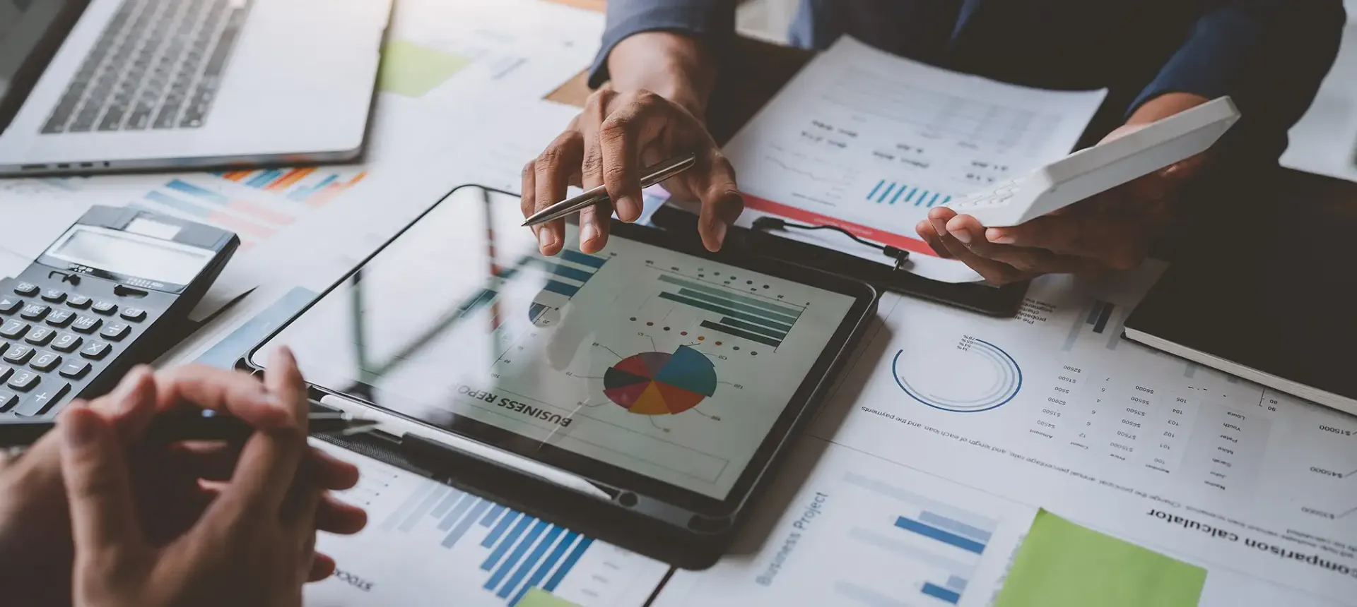 Mortgage professionals reviewing financial data, charts and financing options at a desk.